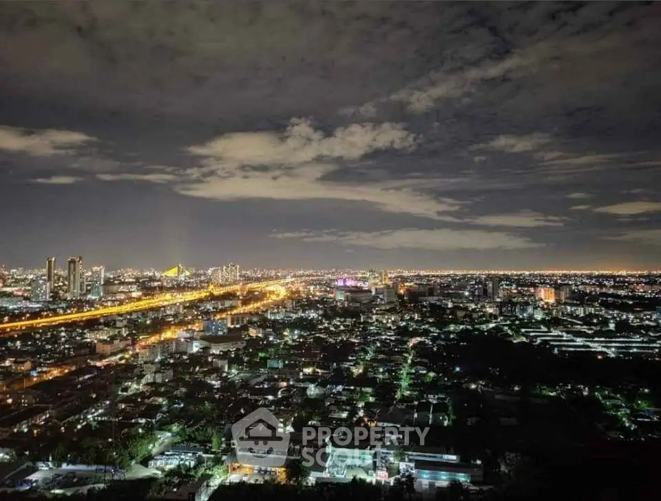Stunning cityscape view from a high-rise building at night, showcasing vibrant city lights and expansive skyline.