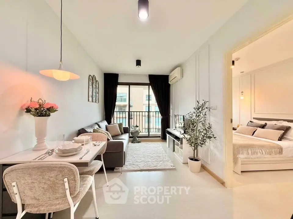 Modern open-plan living room with cozy dining area and stylish bedroom in a bright apartment.