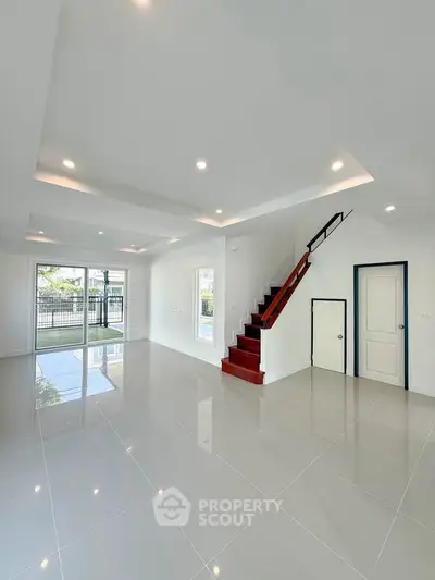 Spacious modern living room with sleek tile flooring and elegant staircase