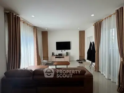 Spacious living room with modern decor and large windows for natural light.