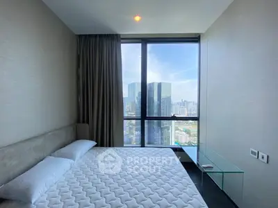 Luxurious bedroom with stunning city view from floor-to-ceiling windows in modern high-rise apartment.