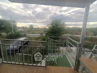 Scenic view from a balcony overlooking lush greenery and a parked car, perfect for nature lovers.