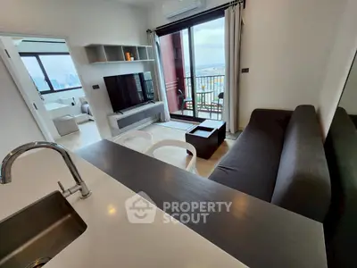 Modern living room with balcony and city view, featuring sleek furniture and open layout.