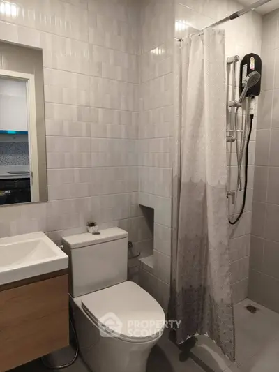 Modern bathroom with sleek fixtures and shower curtain in a contemporary apartment.