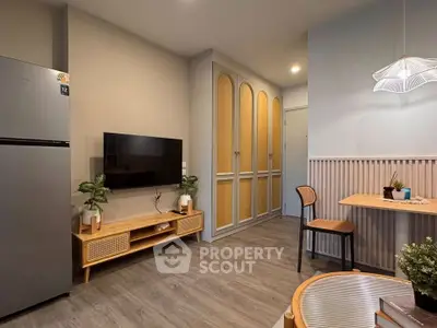 Modern living room with stylish decor and wall-mounted TV, featuring elegant lighting and wooden furniture.