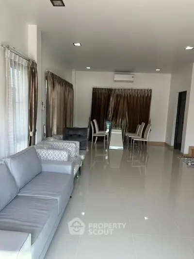 Spacious modern living room with elegant dining area and sleek furnishings