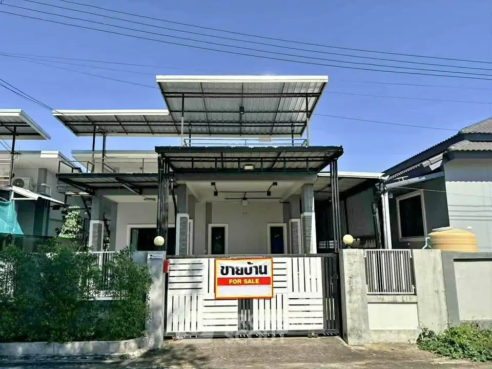 Modern single-story house with solar panels and gated entrance for sale.