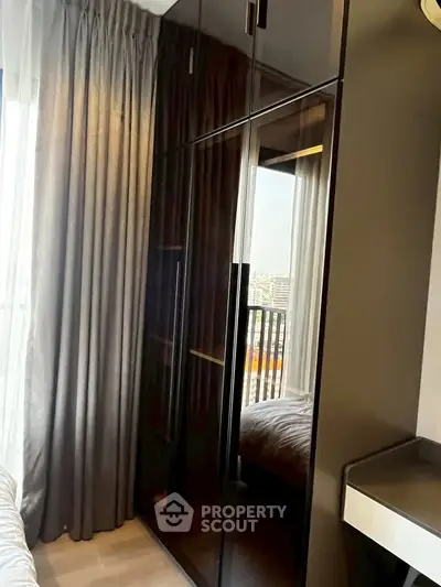 Modern bedroom with sleek wardrobe and balcony view, perfect for urban living.
