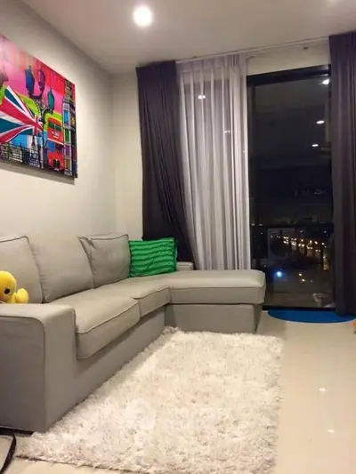Modern living room with stylish decor and city view from large window.