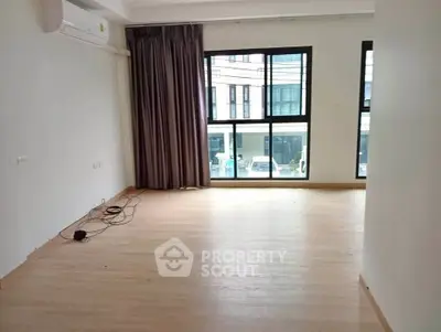 Spacious empty room with large windows and air conditioning unit