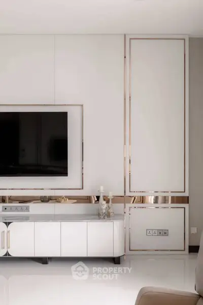 Luxurious modern living room with sleek white cabinetry and large flat-screen TV, perfect for stylish entertainment.
