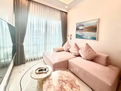 Elegant living room with plush pink sofa, chic decor, and large window for natural light.