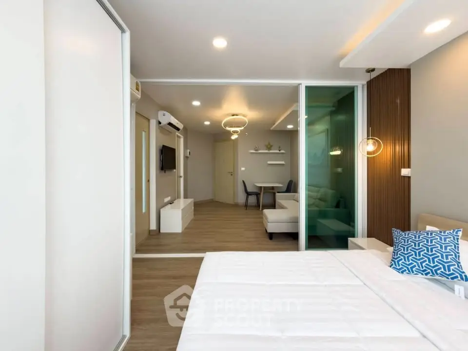 Modern open-plan bedroom with sliding glass doors and stylish living area.