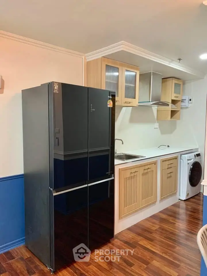 Modern kitchen with sleek black fridge and washing machine