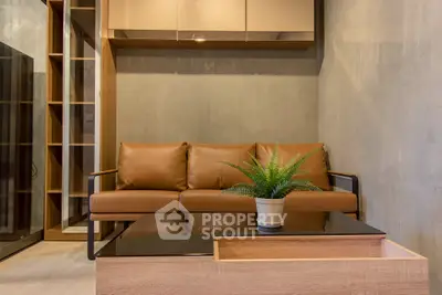 Modern living room with stylish brown leather sofa and sleek wooden coffee table.