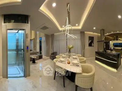 Luxurious open-plan living room with modern kitchen and private elevator, elegant dining area, and stylish lighting.