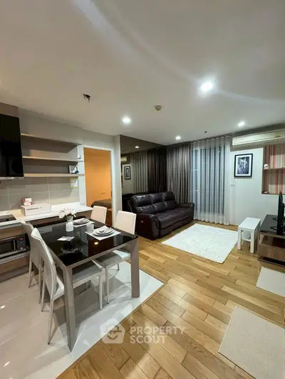 Modern open-plan living room with sleek kitchen and cozy seating area.
