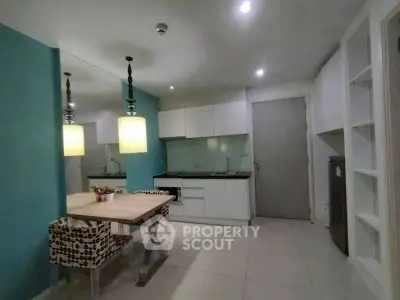 Modern kitchen with dining area, sleek cabinets, and stylish lighting.