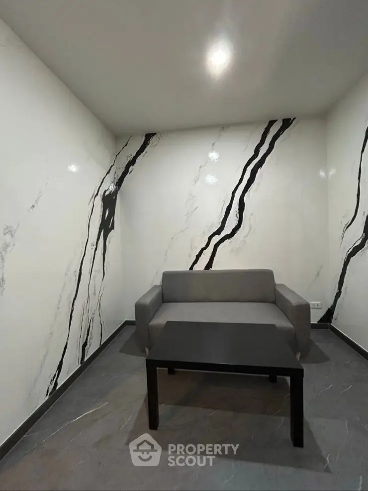 Modern minimalist room with stylish marble accent walls and sleek furniture.