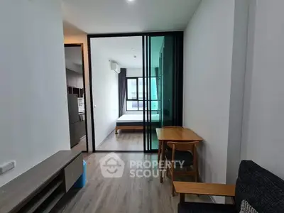 Modern apartment interior with open layout, featuring a cozy living area and a glimpse of the bedroom.