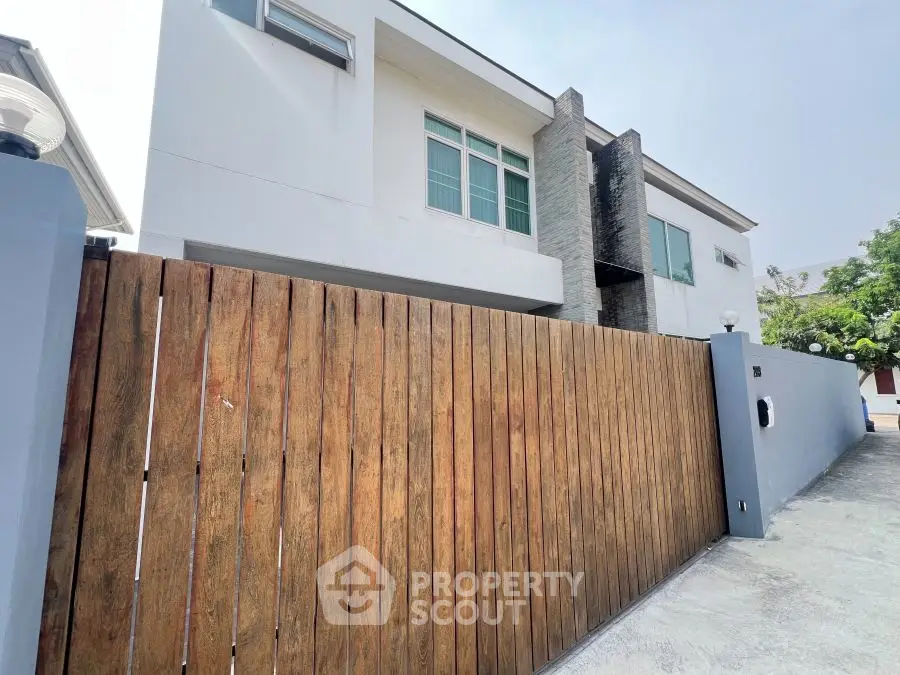 Modern two-story house with wooden fence and sleek exterior design