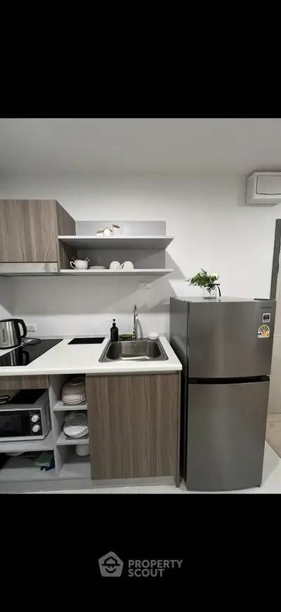 Modern kitchen with sleek cabinets, stainless steel fridge, and built-in oven