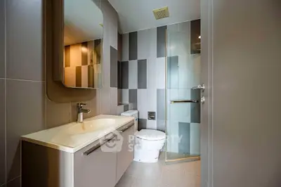 Modern bathroom with sleek design, featuring a large mirror, stylish sink, and glass shower enclosure.