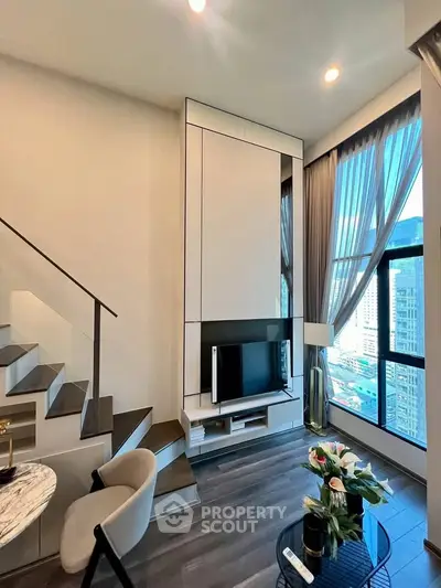 Modern living room with high ceilings, large windows, and stylish decor in a luxury apartment.