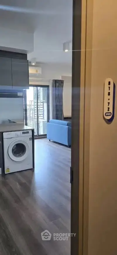 Modern apartment interior with washing machine and balcony view