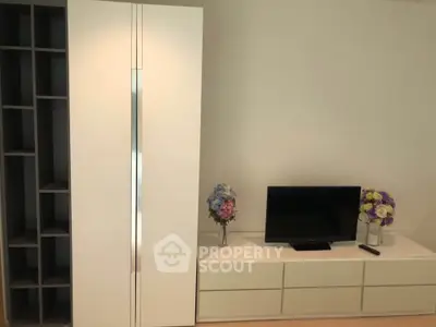 Modern living room with sleek storage and TV unit, featuring elegant floral decor.