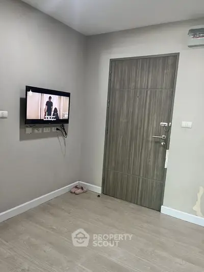Modern minimalist interior with wall-mounted TV and sleek wooden door