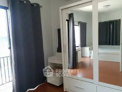 Spacious bedroom with mirrored wardrobe and elegant curtains