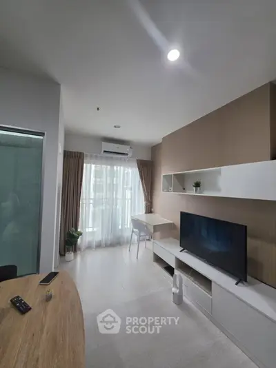 Modern living room with sleek furniture and natural light from large windows.