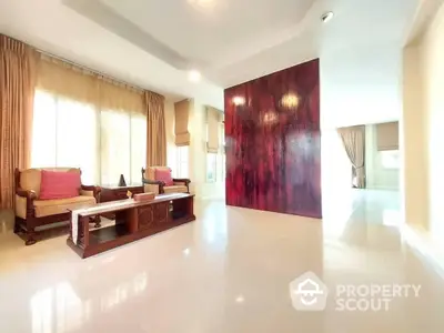 Spacious and bright living room with glossy tiled floors, elegant traditional furniture, and a bold red accent wall creating a luxurious atmosphere.