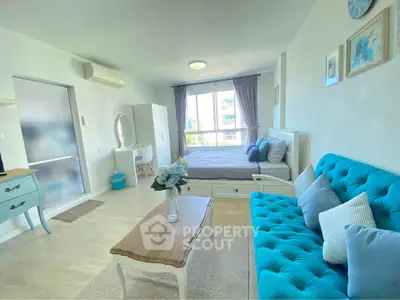 Bright and airy studio apartment with modern furnishings and large window view.