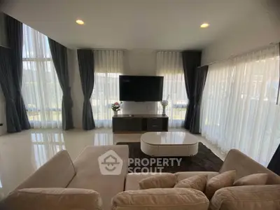 Spacious modern living room with large windows and elegant furnishings