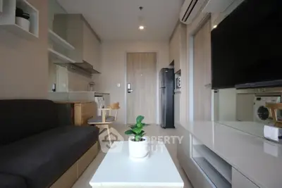 Modern living room with sleek furniture and integrated kitchen appliances in a stylish apartment.