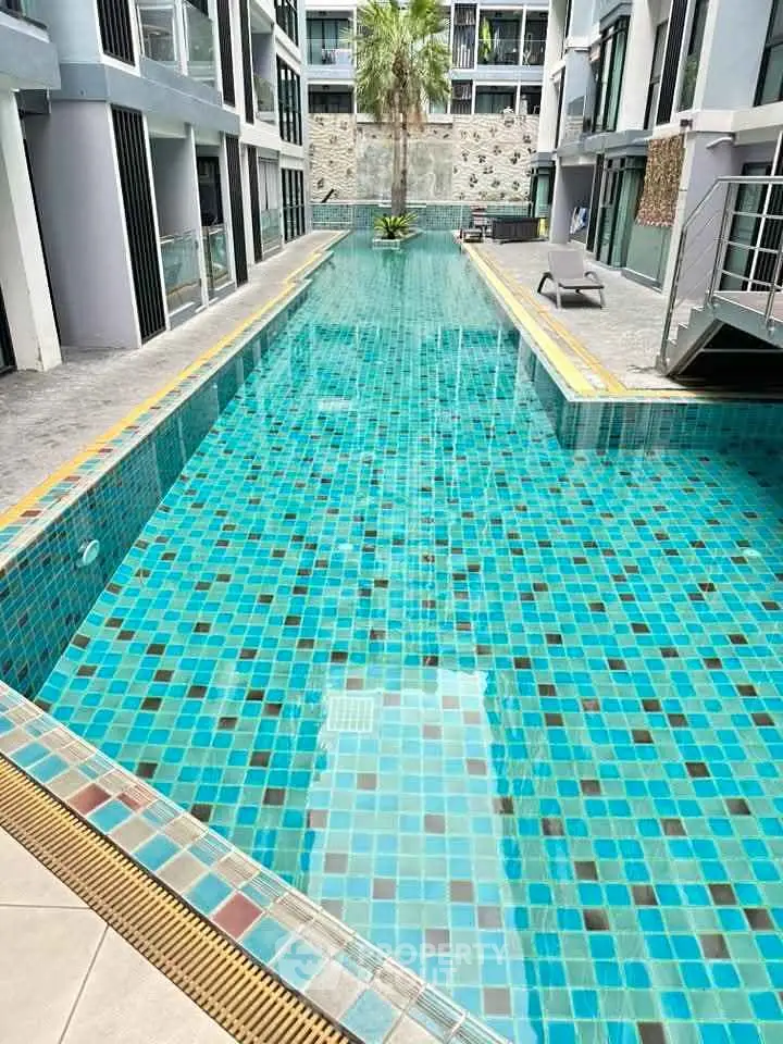 Luxurious modern apartment pool with vibrant blue tiles and sleek architecture.