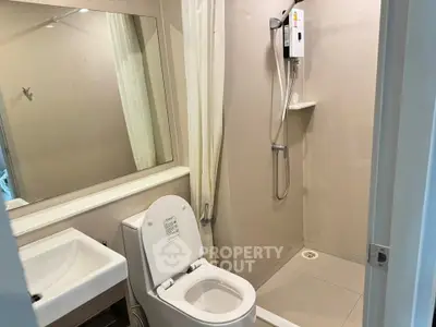Modern bathroom with shower and toilet in sleek minimalist design.