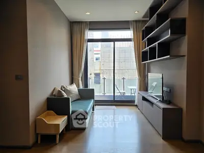 Modern living room with sleek furniture and large window offering city view.