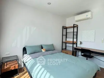 Modern bedroom with minimalist decor, featuring a cozy bed, desk, and air conditioning.