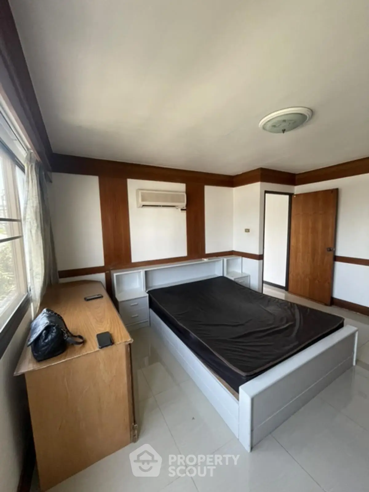 Spacious bedroom with natural light and modern furnishings