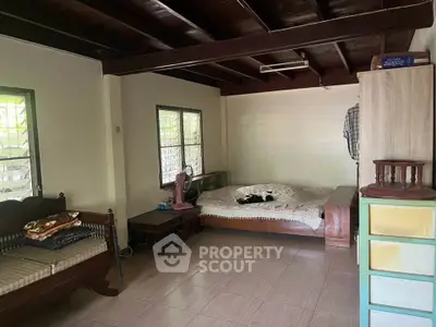 Cozy living room with wooden ceiling and tiled floor, featuring a daybed and classic furniture.