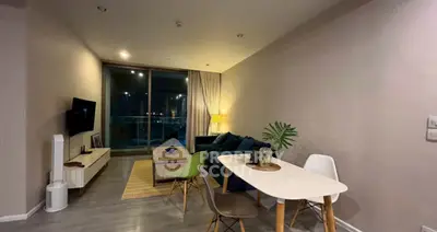 Modern living room with stylish furniture and large window offering city view
