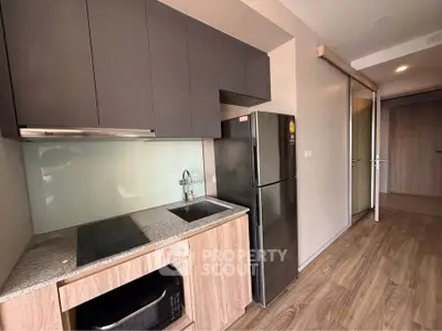 Modern kitchen with sleek cabinetry and stainless steel appliances in a stylish apartment.