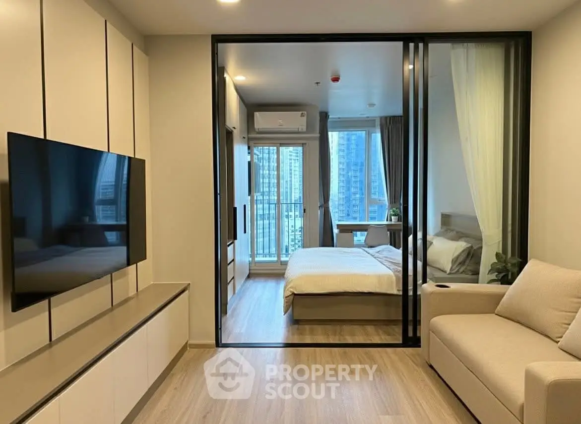 Modern apartment with glass partition, cozy living room, and stylish bedroom view.