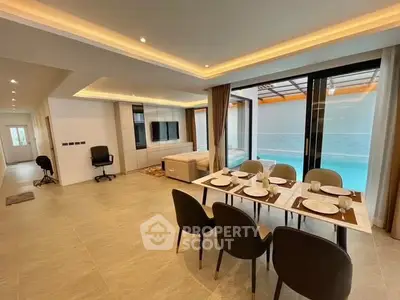 Luxurious open-plan living room with pool view and elegant dining area.