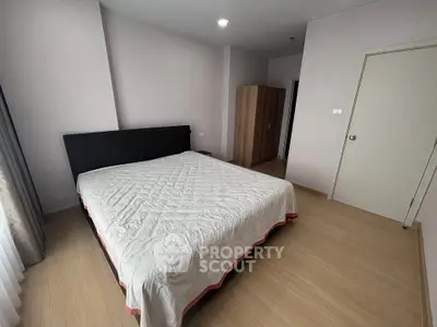 Spacious bedroom with modern decor and large bed in a well-lit apartment.