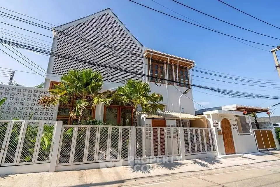 Modern architectural house exterior with unique facade and lush palm trees