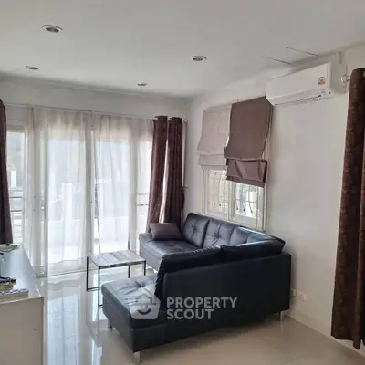 Modern living room with sleek black sofa and natural light